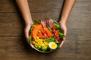 person holding a bowl of vegetables