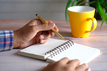 Close up of man hand writing on notepad.