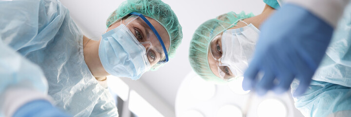 Fototapeta premium Group of doctors performing surgical operation in clinic