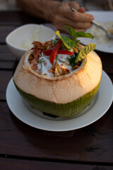 Thai  spicy food , Curry Streamed Seafood in Coconut Cup placed on a white plate.