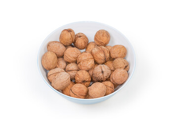 Whole walnuts in their shells in bowl close-up