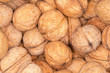 Background of unshelled walnuts pile, top view close-up