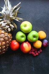 Various colorful fruit on dark background. Flat lay.