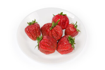 Big berries of strawberry with tails on dish, close-up
