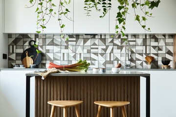 Stylish kitchen interior design with dining space. Workspace with kitchen accessories on the back ground. Creative walls. Minimalistic style an plant love concept.