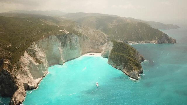 4K Aerial footage of Navagio Beach known as Shipwreck Beach or Shipwreck Cove located in Zakynthos island in Greece. Turquoise clean water with no tourist.