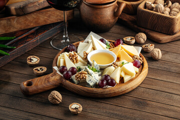 Cheese wine appetizer platter with grapes nuts and honey