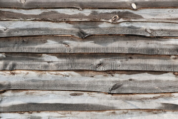 The texture of an old wooden fence made of uneven horizontally placed boards.