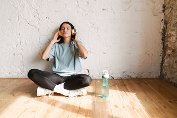 Smiling young white sporty woman in earphones