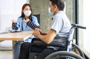 Young asian woman doctor encouragement and supportive to cansor patient after consult and examine in clinic hospital health ideas concept. Problem talk at medical checkup visit with wheelchair .