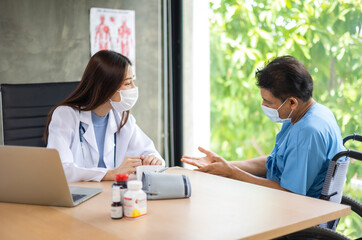 Obraz premium Young asian woman doctor encouragement and supportive to cansor patient after consult and examine in clinic hospital health ideas concept. Problem talk at medical checkup visit with wheelchair .