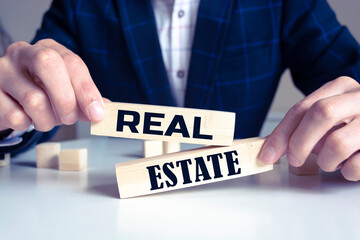 Obraz premium Real estate text from wooden blocks on desk