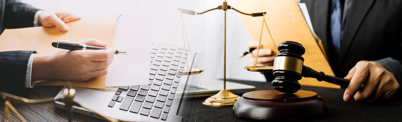 Justice and law concept.Male judge in a courtroom with the gavel, working with, computer and docking keyboard, eyeglasses, on table in morning light