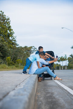 Vertical Shot Of A Latina Mom Trying To Take A Picture With Her Sons On The Street