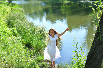 Girl in beautiful wreath on summer meadow near the river. Feast of Ivan Kupala.Midsummer. Earth...