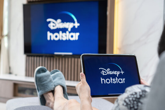 Bangkok, Thailand - July 13, 2021: Disney+ Hotstar Movie App Logo On Ipad And Smart TV Television Screen Sharing In Home Living Room For Popular TV Show Watching During New Normal Lifestyle