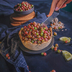Open pie with wild gooseberry and lemon cream on dark wooden background. Rustic photography.