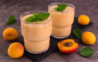 Apricot smoothie on a gray background.
Two glasses of apricot smoothie.