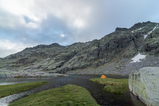 Tent on grassy shore of mountain lake