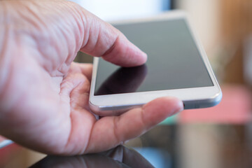 Digital Smartphone disruption concept, Hand holding mobile for searching information data internet at anywhere in office over blur background. Technology / internet of things for new generation