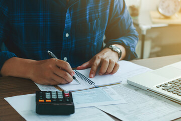 Man doing finances and calculate about cost to real estate investment and in other, tax system.Time for Taxes Money Financial Accounting Taxation Concept - obrazy, fototapety, plakaty