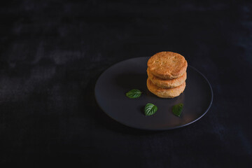 Vegetarian tofu pancakes with strawberry sauce and mint on black background.