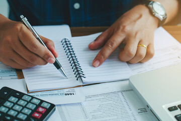 Man using calculate domestic bills on wooden desk in office and business working background.Young...