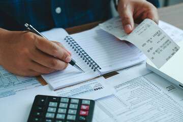 Man using calculate domestic bills on wooden desk in office and business working background.Young...