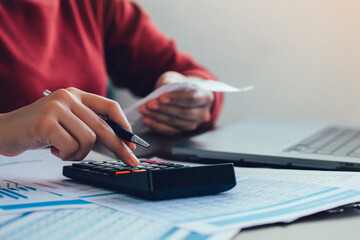 Fototapeta premium Close up woman hand using a calculator and the other hand holds the bill with calculate about finance accounting. finance accounting concept