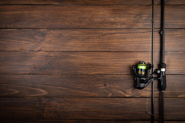 Fishing tackle - fishing spinning rod, hooks and lures on wooden background. Active hobby...