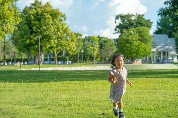 Little girl running outdoor at grass field.