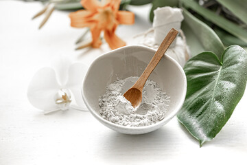 Spa composition with powder face mask and flowers.