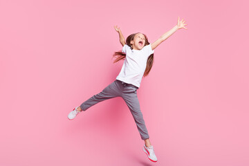 Fototapeta na wymiar Full length body size view of pretty carefree cheerful girl jumping having fun good mood isolated over pink pastel color background