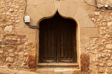 Puerta de madera antigua con dintel decorativo.