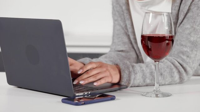 close up details woman typing on laptop enjoy red wine businesswoman working at home