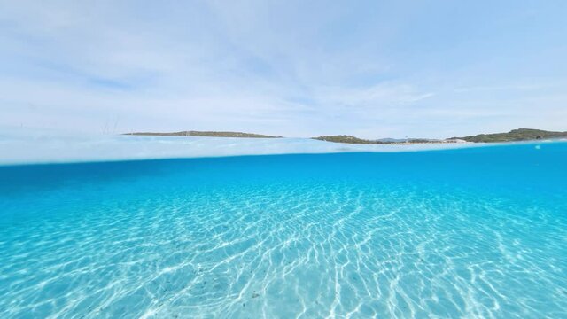 Split-shot, over-under shot. Stunning view of half underwater half sky with a beautiful and turquoise water. Liscia Ruja, Sardinia, Italy.