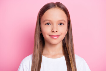 Photo of happy positive good mood lovely little girl with long brown hair smiling isolated on pink color background