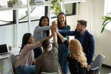 Happy overjoyed mixed race millennial team celebrating success, work achieve, giving high five,...