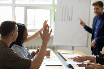 Audience raising hands up for asking question to presenter on office meeting in boardroom. Business leader, coach, mentor giving training, answering to engaged students, interns, employees