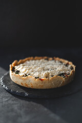 Millet quiche with spinach, salmon, broccoli and ricotta on dark wooden table. Homemade 
vegetarian cake. Copy space for text. Fresh pie with soft cheese. Healthy food. French cuisine