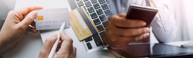 male hands holding a credit card and use mobile phone for Online payment online shopping