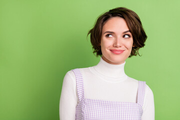 Photo of young woman happy positive smile dream curious look empty space isolated over green color background