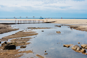 Creek bay on the beach with litle wooden bridge