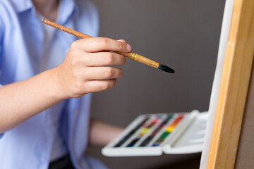 A woman's hand with a brush for drawing.