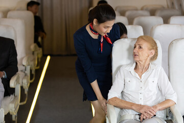 air hostess talking with senior passengers on airplane