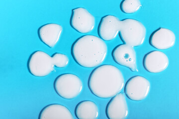 Abstract background with white liquid drops. Cosmetic texture concept. Moistutizing SPF sunscreen summer lotion with natural ingredients, anti-aging
