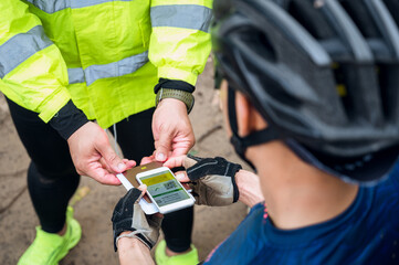 Fototapeta premium Selective focus, Mountain bike athlete show health passport of vaccination certification on phone at bicycle race track, to certify have been vaccinated of coronavirus. Sport during Covid-19 pandemic.