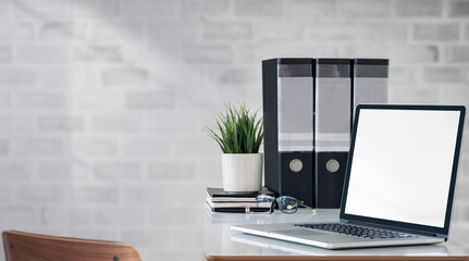 Laptop with blank screen on the table, home office concept.
