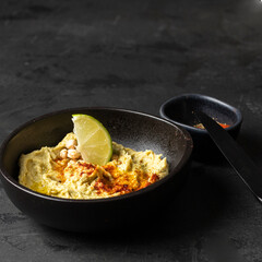 Cheakpea Hummus bowl with red smoked paprika and lime. Healthy snack concept.