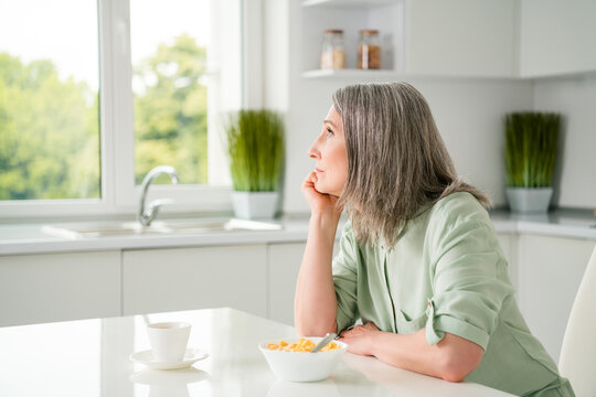 Profile side view portrait of attractive dreamy grey-haired woman dreaming eating useful lunch at home light white indoors